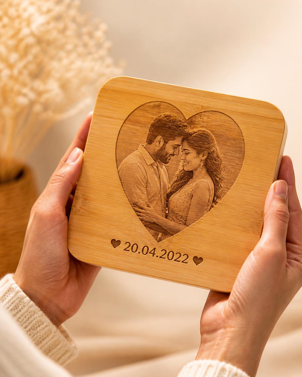 Hands holding a bamboo anniversary keepsake engraved with a heart photo